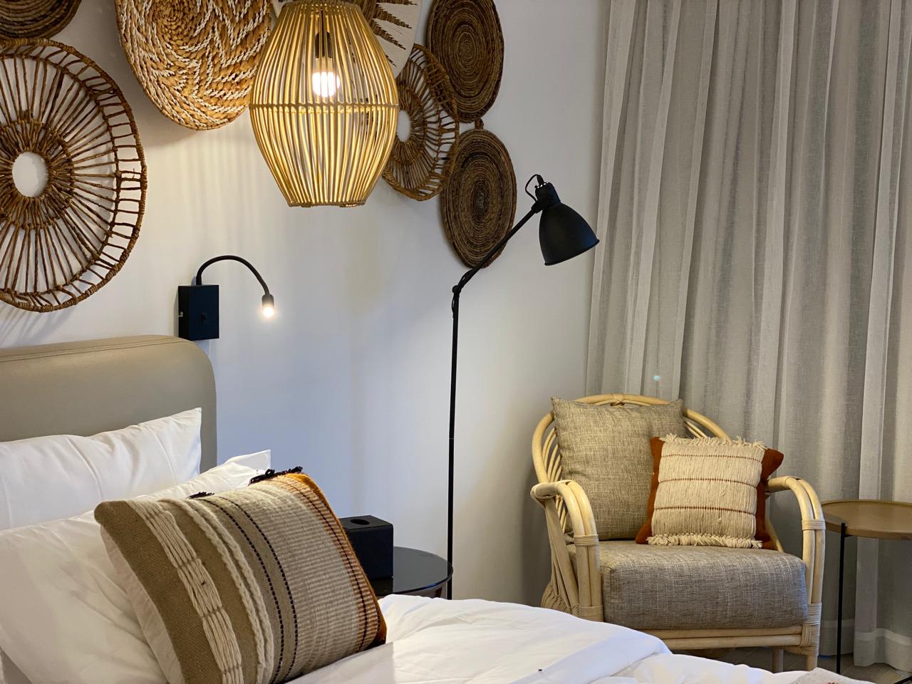 Bedside corner with rattan chair and warm lighting